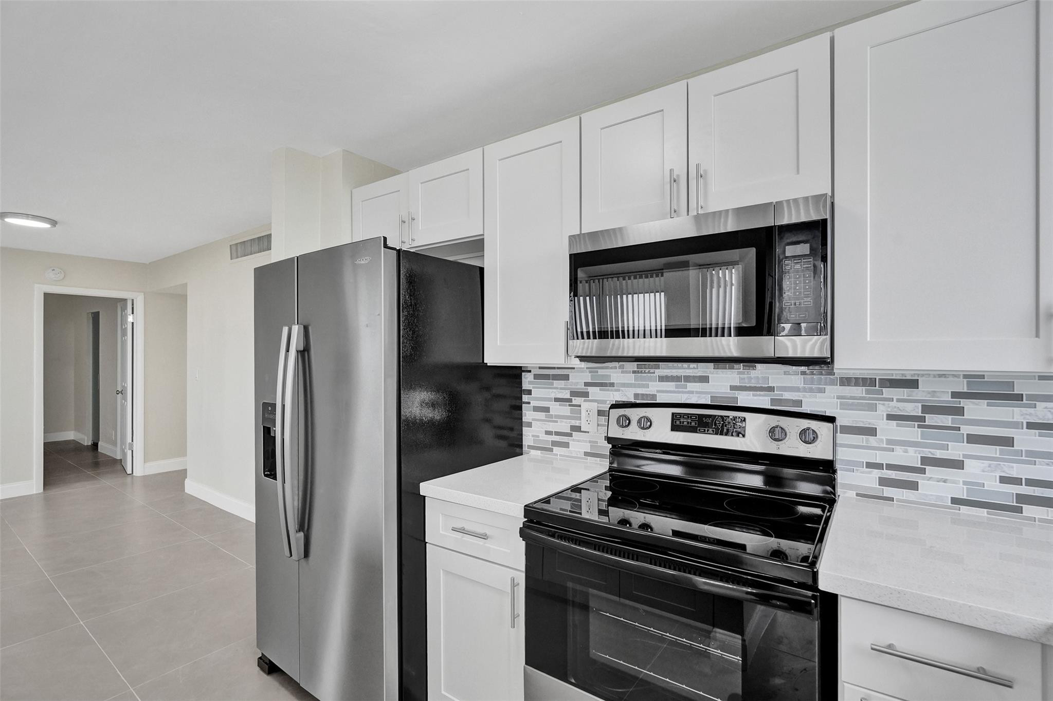 4222 Inverrary Boulevard, Unit 4810 Lauderhill, FL 33319 - Photo 10 of 63 a kitchen with cabinets and steel stainless steel appliances