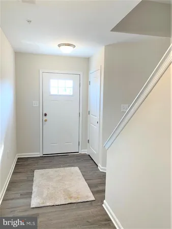 an empty room with wooden floor and entrance