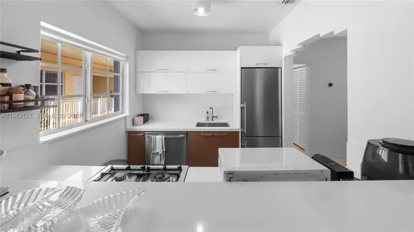 a kitchen with a refrigerator a stove a sink and a window