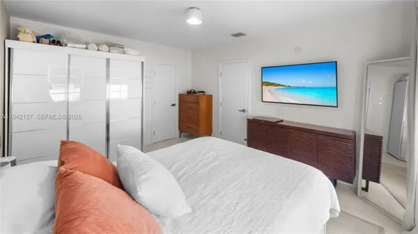 a bedroom with a bed and a flat screen tv