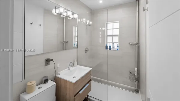 a bathroom with a sink a toilet and shower