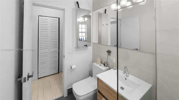 a bathroom with a sink a toilet and shower