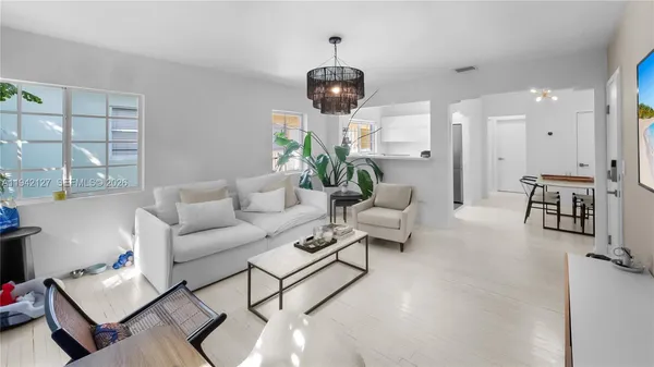 a living room with furniture and a chandelier