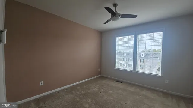 a view of a livingroom with a ceiling fan and window