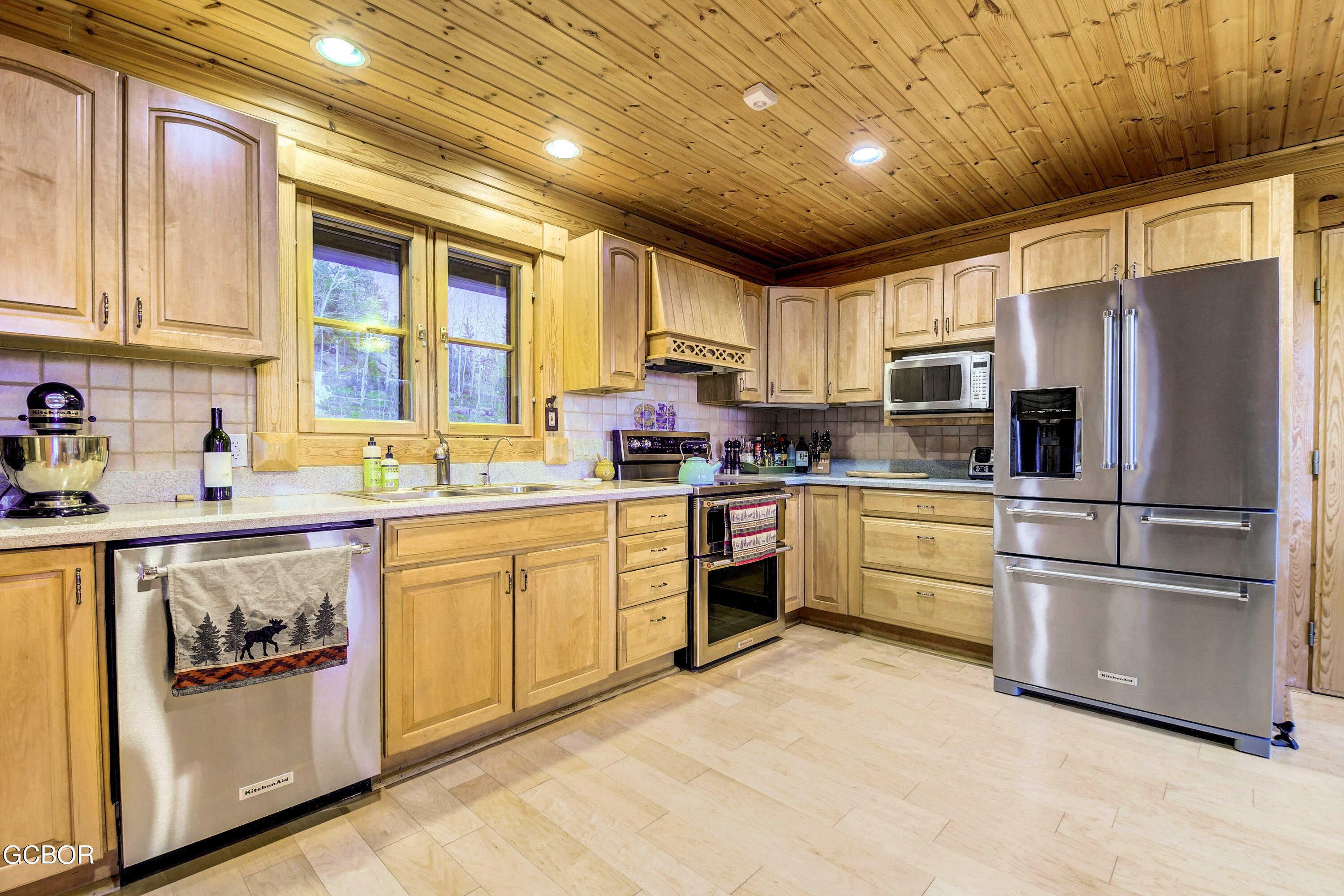11006 Timothys Drive Conifer, CO 80433 - Photo 15 of 45 a kitchen with stainless steel appliances granite countertop a refrigerator oven a sink dishwasher and white cabinets with wooden floor
