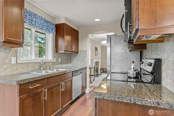 a kitchen with stainless steel appliances granite countertop a sink stove and cabinets