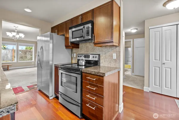 a kitchen with stainless steel appliances granite countertop a refrigerator and a stove top oven