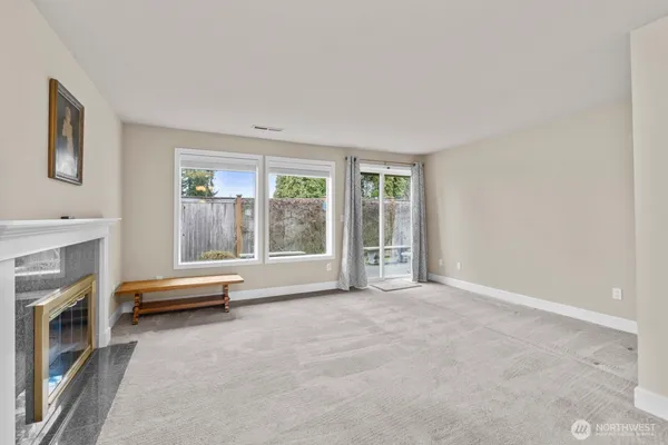 an empty room with fireplace and windows