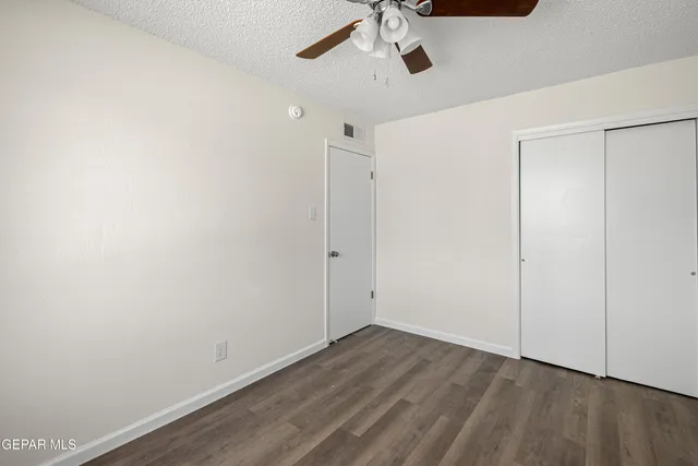 an empty room with a window and a ceiling fan
