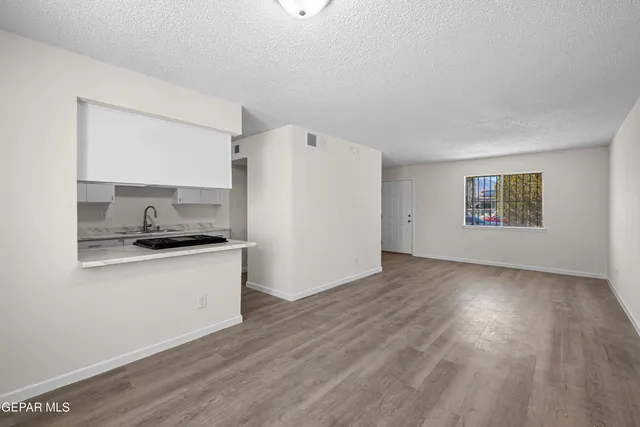 a kitchen with granite countertop a stove a sink and a refrigerator