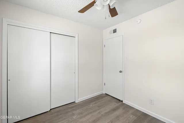 an empty room with a window and a fan