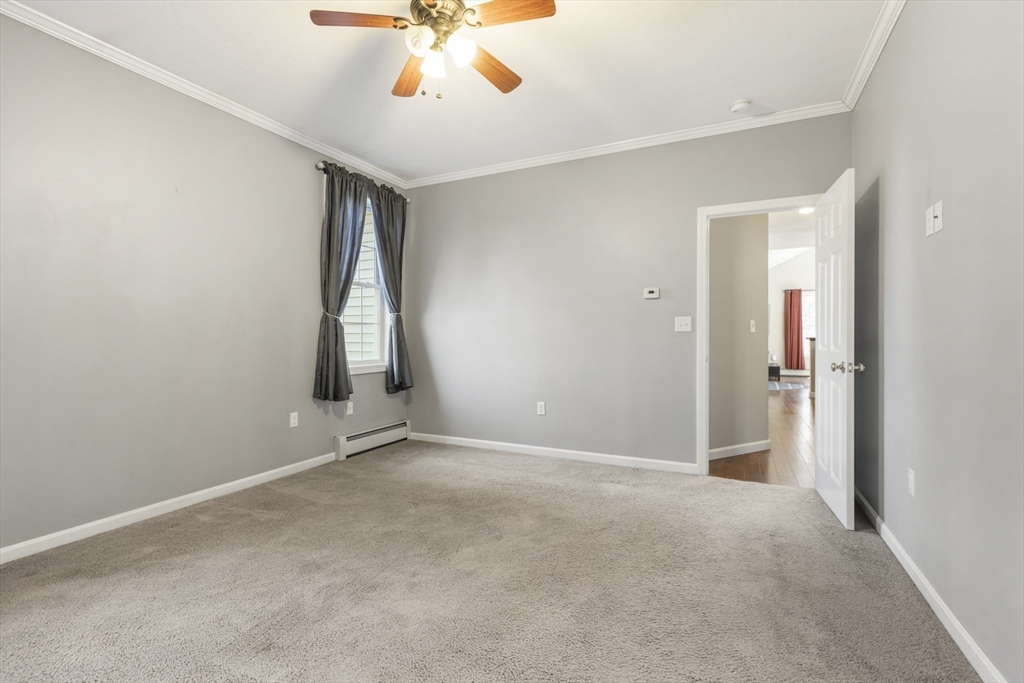 204 Brookfield Road Charlton, MA 01507 - Photo 19 of 36 an empty room with a chandelier fan and windows