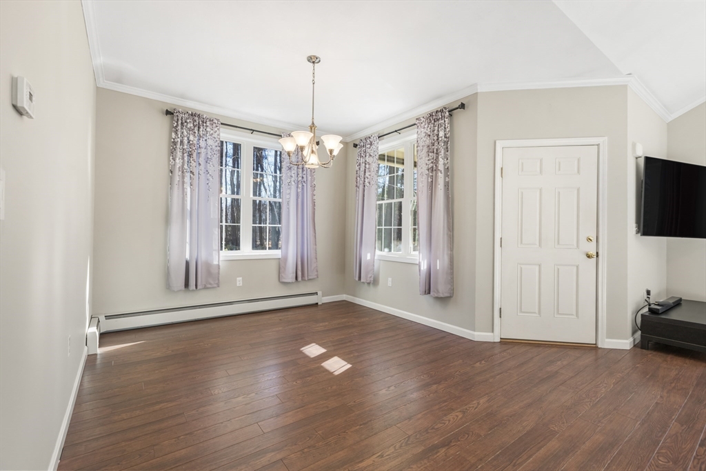 204 Brookfield Road Charlton, MA 01507 - Photo 7 of 36 a view of a livingroom with wooden floor a flat screen tv and a window