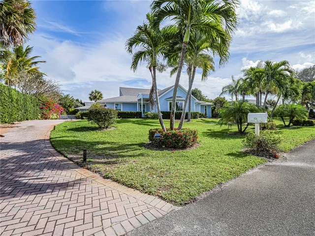 a front view of a house with garden and trees