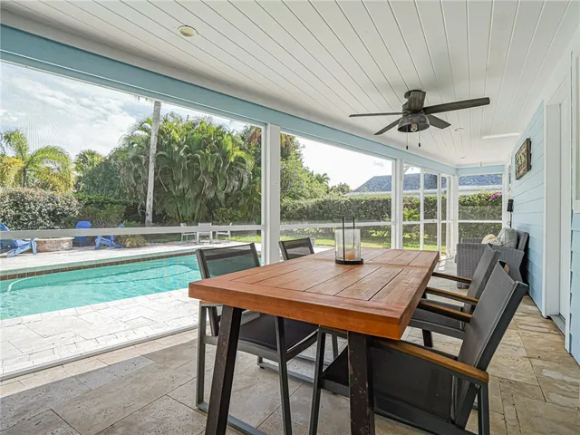a view of a patio with a table chairs and a small yard
