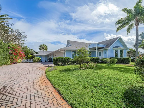 a front view of a house with a yard and potted plants