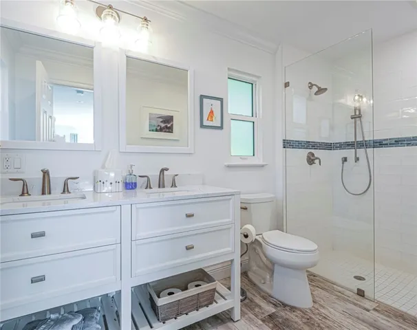 a bathroom with a toilet sink vanity and shower
