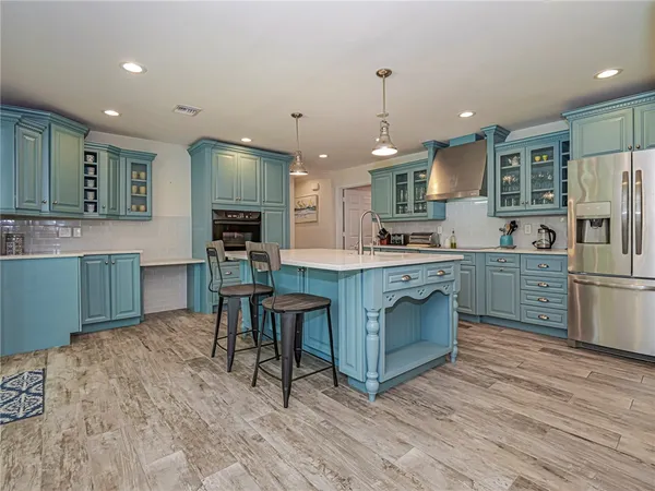 a kitchen with kitchen island granite countertop a sink cabinets and wooden floor