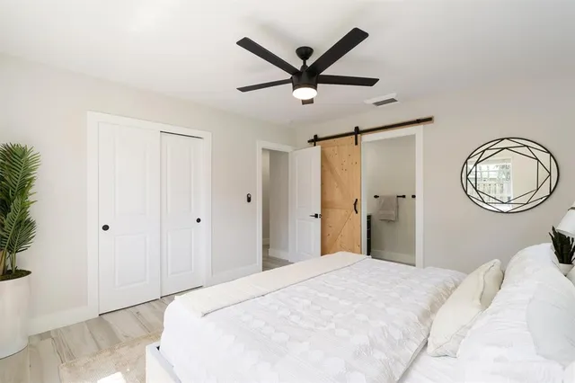 a bedroom with a large bed and a chandelier