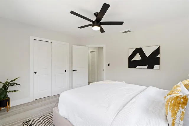a bedroom with a bed and a ceiling fan