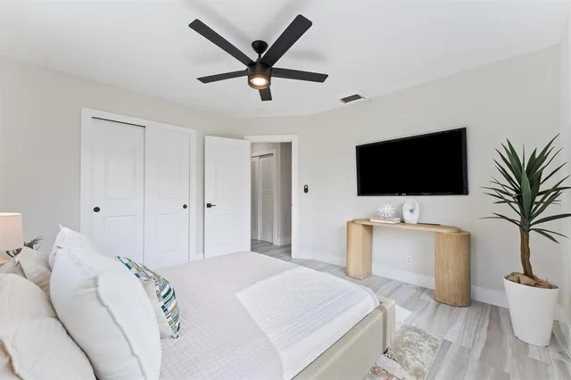 a bedroom with a bed tv and wooden floor