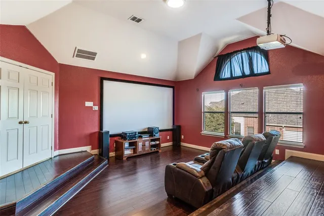 an empty room with wooden floor cabinet and windows