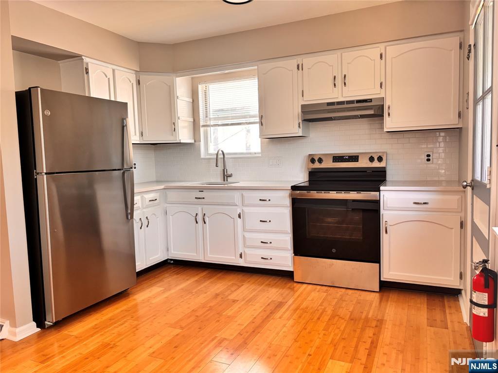 21 Wanamaker Avenue, Unit 1 Waldwick, NJ 07463 - Photo 3 of 13 a kitchen with stainless steel appliances a refrigerator sink and cabinets
