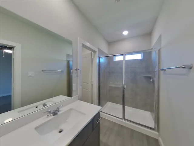 a bathroom with a shower sink and mirror