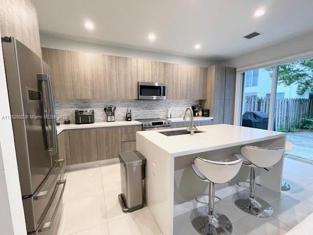 Doral Doral, FL 33178 - Photo 7 of 38 a kitchen with a sink a refrigerator and a stove top oven