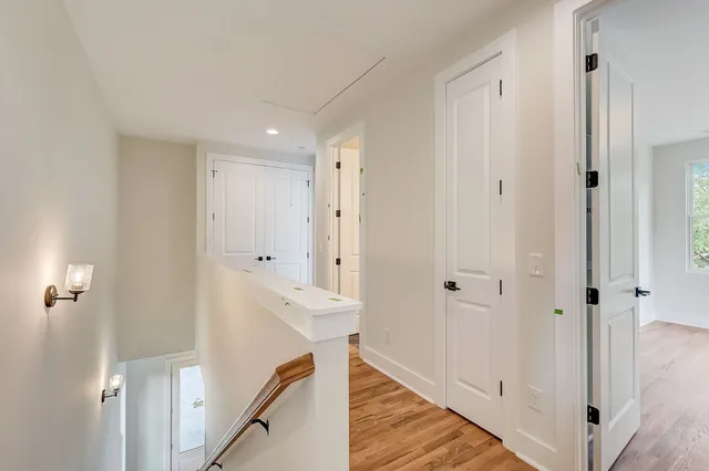 a view of a hallway with wooden floor and staircase