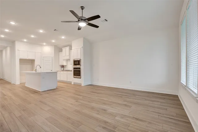 a view of an empty room with a fireplace and wooden floor