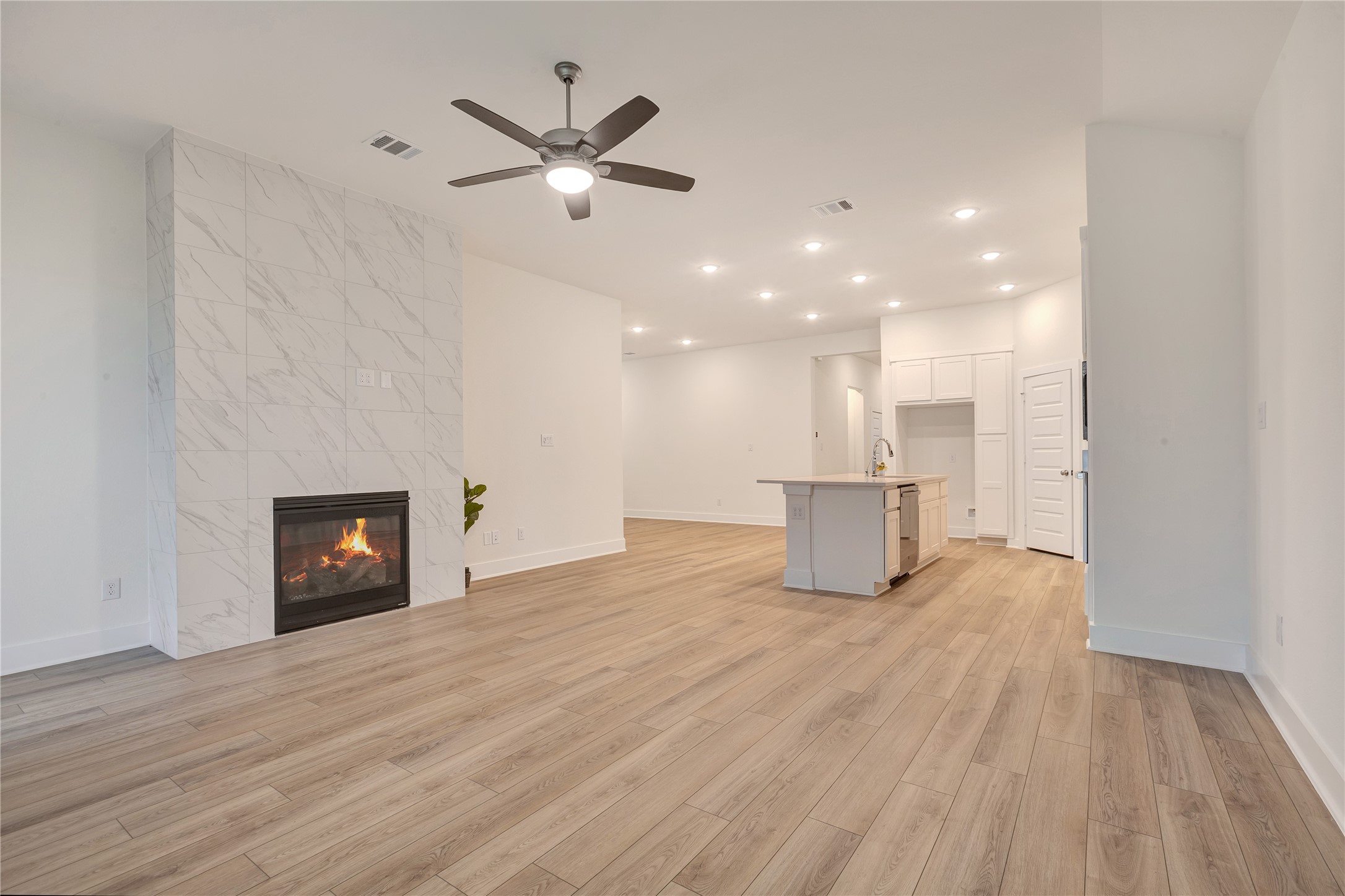 6027 Churchill Spgs Lane Fulshear, TX 77441 - Photo 14 of 25 a view of an empty room with a fireplace and wooden floor