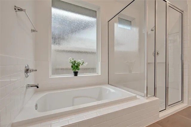 a spacious bathroom with a tub sink and mirror