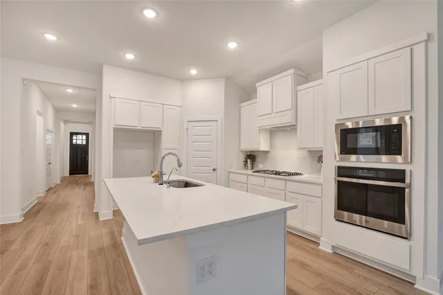 a kitchen with stainless steel appliances kitchen island granite countertop a stove sink and microwave