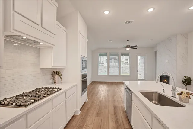 a kitchen with sink stove and cabinets