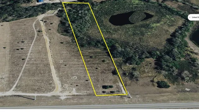 a picture of a field with a white wall