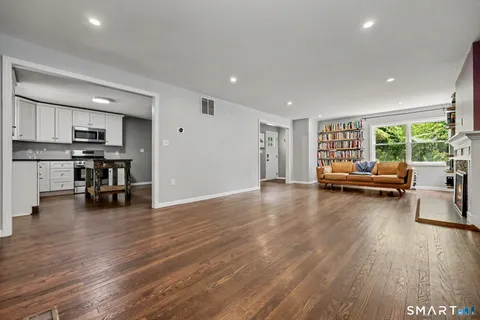 a living room with furniture and a wooden floor