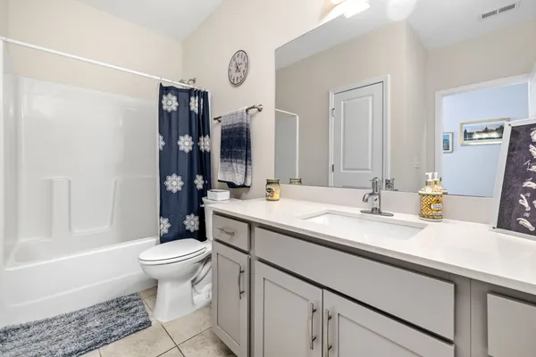 a bathroom with a granite countertop sink toilet and shower