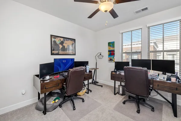 a view of a workspace with furniture and a window