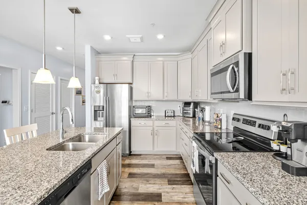 a kitchen with stainless steel appliances granite countertop a sink stove and refrigerator