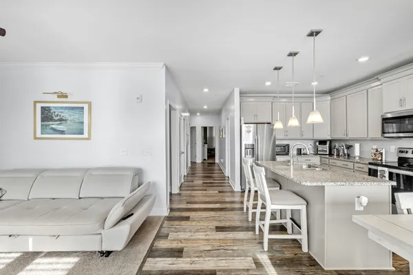 a view of a kitchen with kitchen island white cabinets and stainless steel appliances