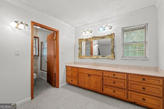 a spacious bathroom with a granite countertop sink mirror and window