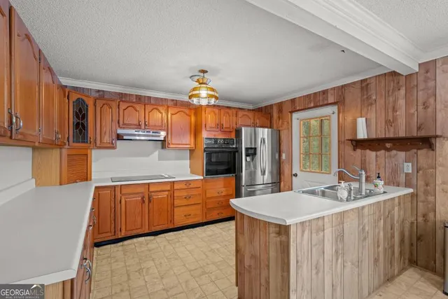a kitchen with stainless steel appliances kitchen island granite countertop a sink and a refrigerator