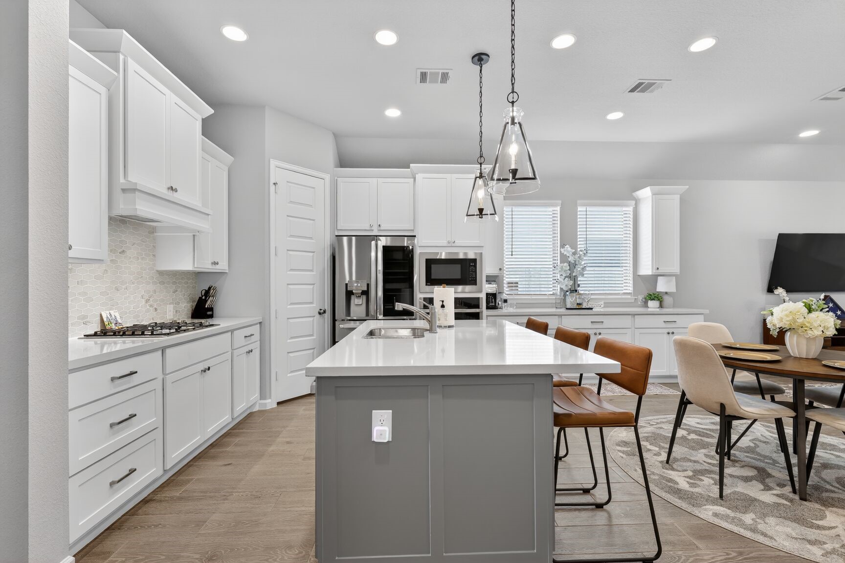 11231 Burgus Farm Road Humble, TX 77346 - Photo 8 of 28 Highlighting the oversized quartz island, gas cooktop, and the versatile dry bar addition. High ceilings and recessed LED lighting illuminate the open-concept layout, while the walk-in pantry offers incredible storage capacity.