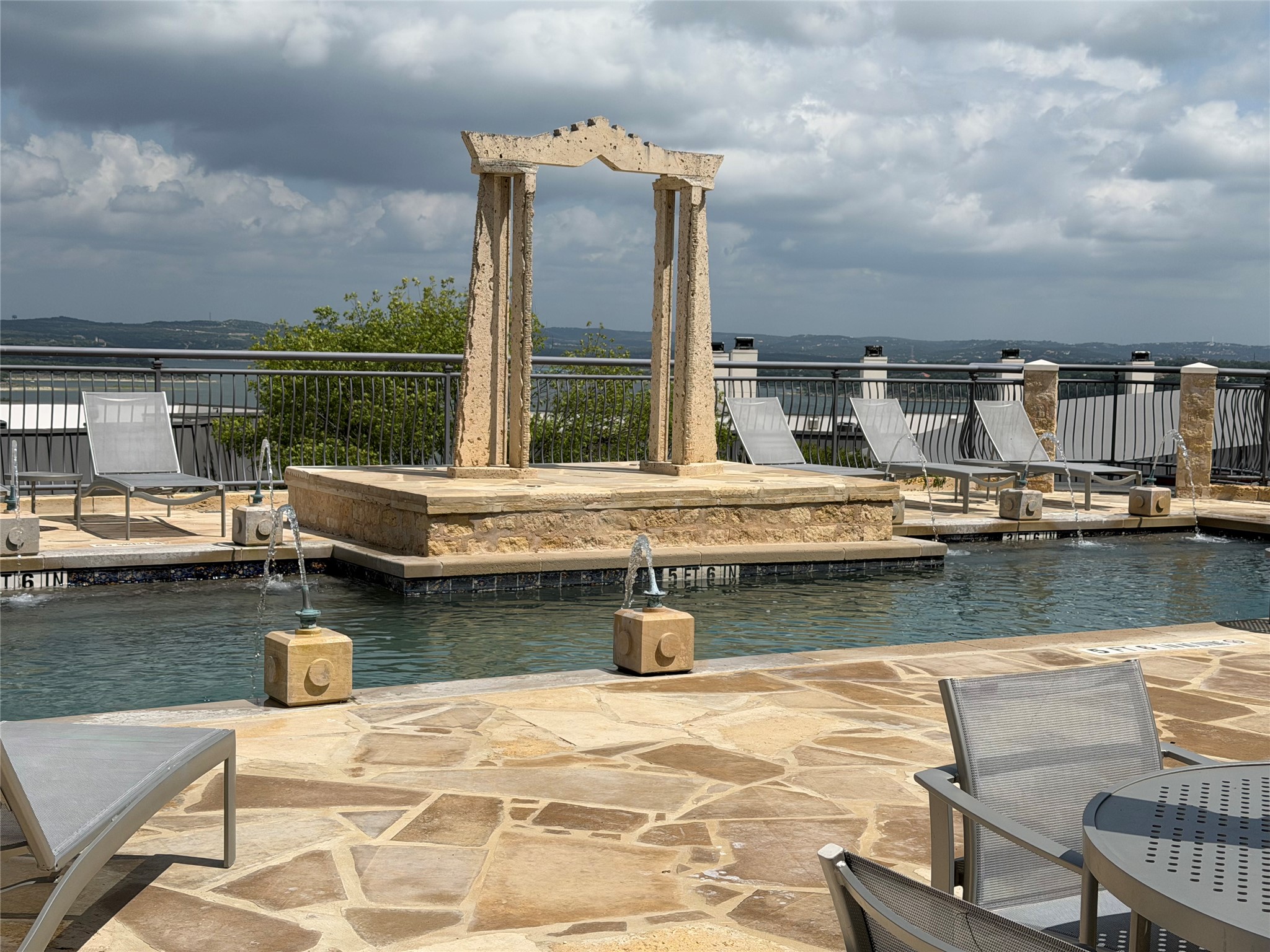 2918 Ranch Road 620 North, Unit C120 Austin, TX 78734 - Photo 26 of 34 The pool area on the North side with flagstone patio offers serene views under a dramatic sky.