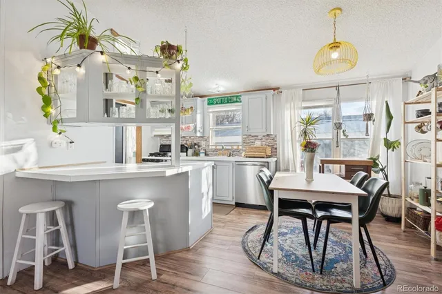a kitchen with cabinets a sink dining table and chairs