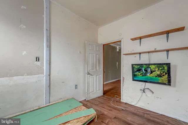 a living room with a flat screen tv and a wooden floor