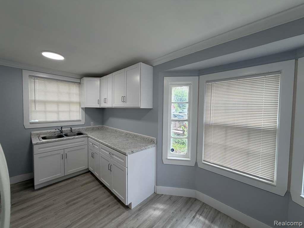 7416 Heyden Detroit, MI 48228 - Photo 10 of 16 Kitchen featuring white cabinetry, light countertops, and light wood-style floors