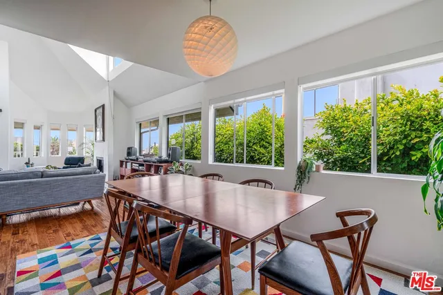 a dining room with furniture a rug and a floor to ceiling window