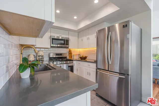 a kitchen with a refrigerator a stove and a sink